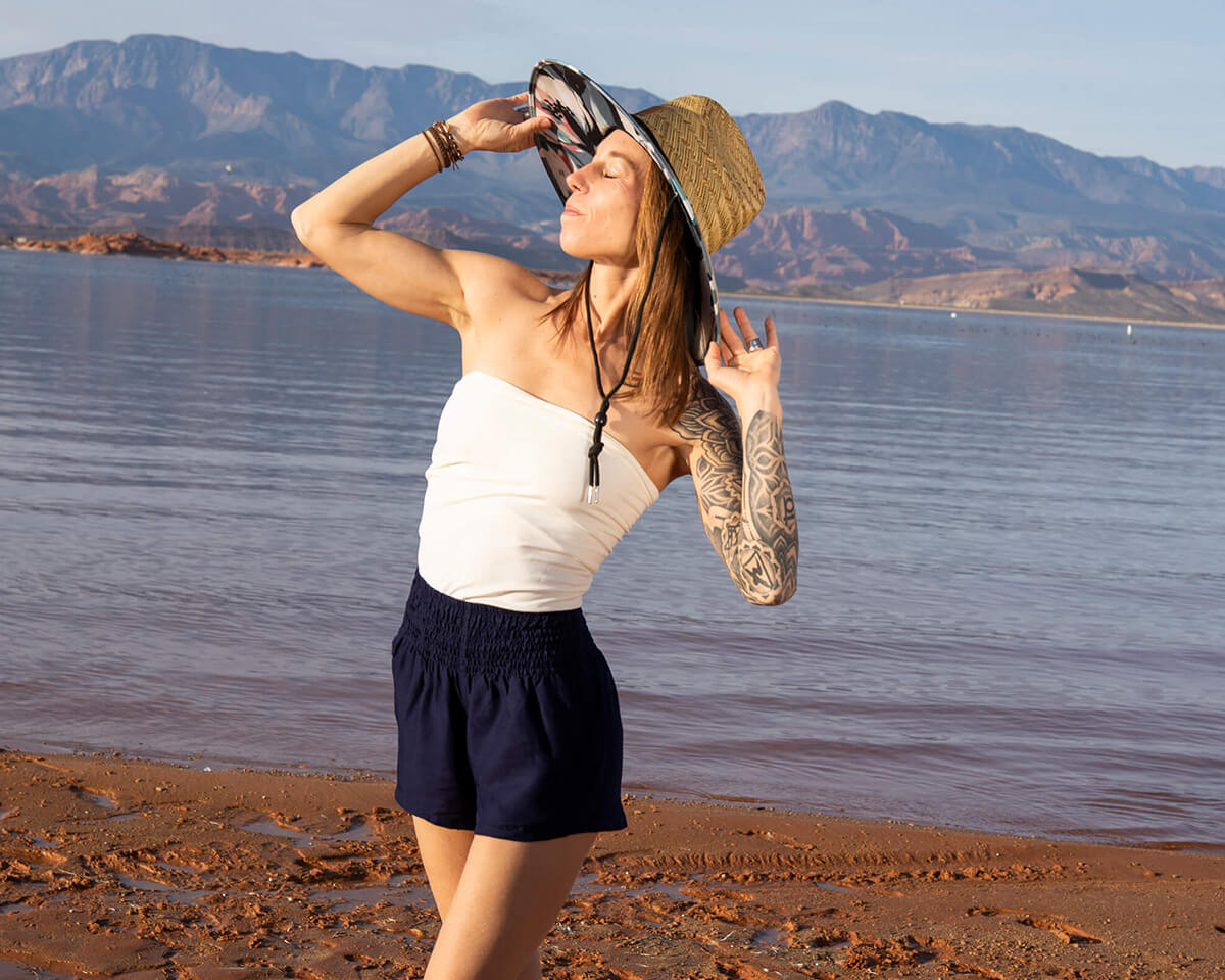 Woman wearing flowy Charlee Girl travel outfit with harem pants and straw sun hat outdoors