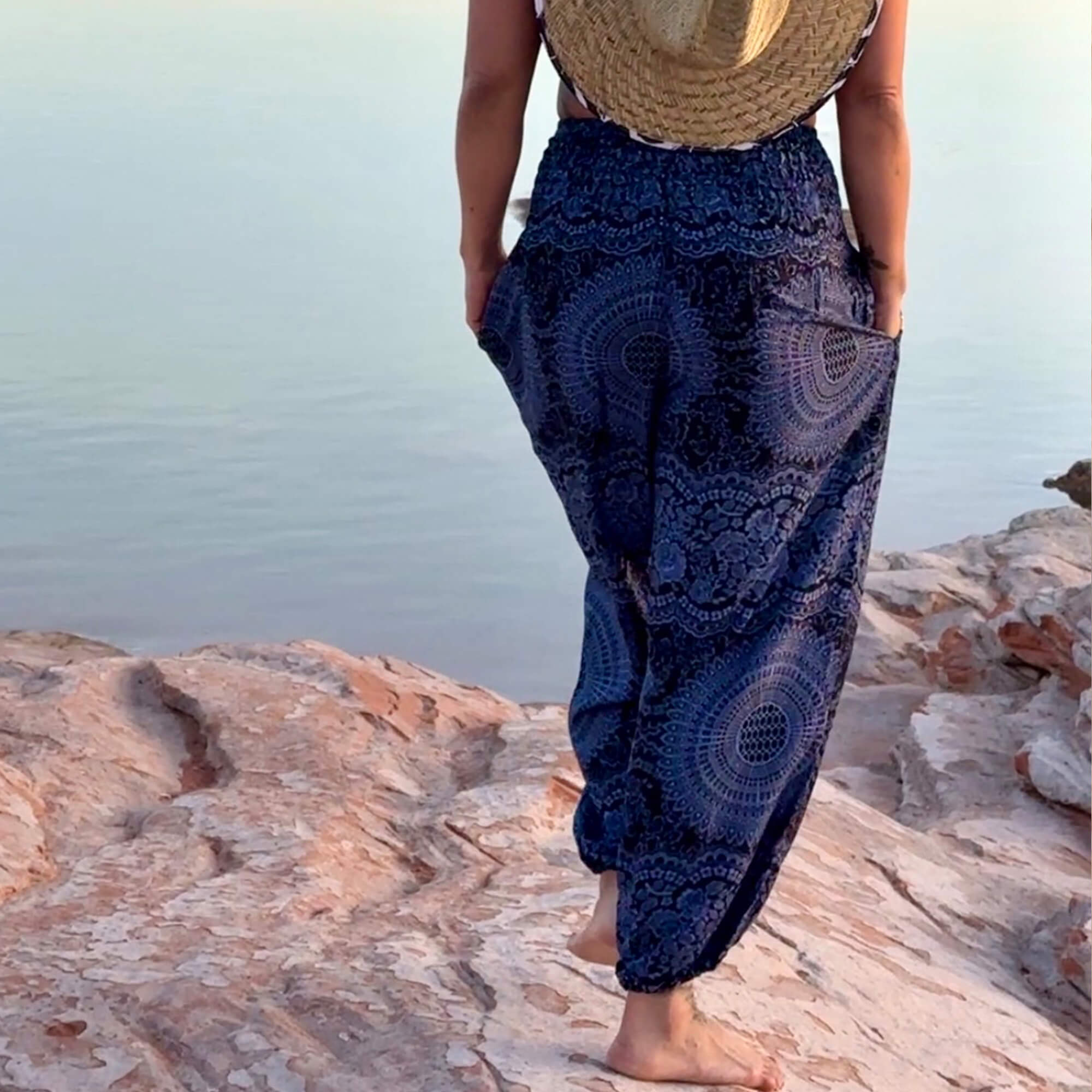 Woman wearing flowing Charlee Girl Water Collection pieces in ocean-inspired tones near the water