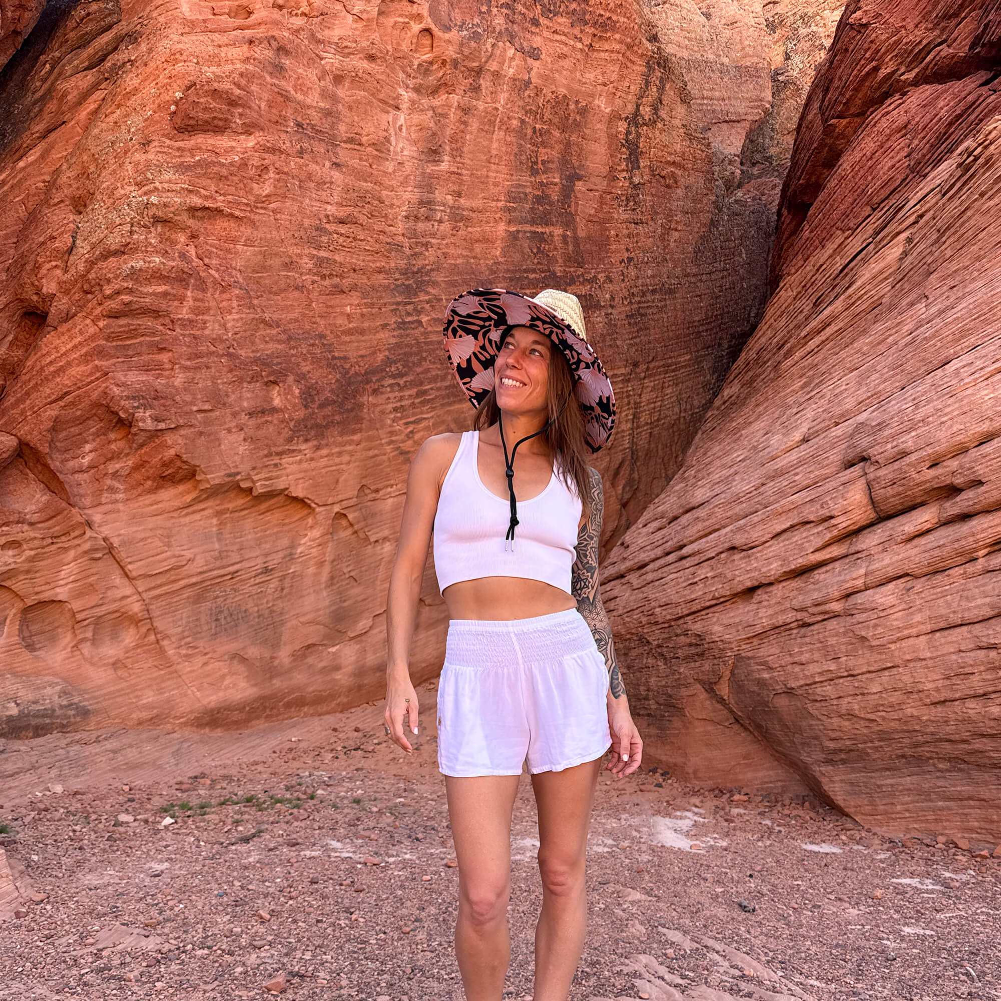 Karlene wearing The Anna Hollow Mat straw sun hat with white shorts — lifeguard style boho sun hat