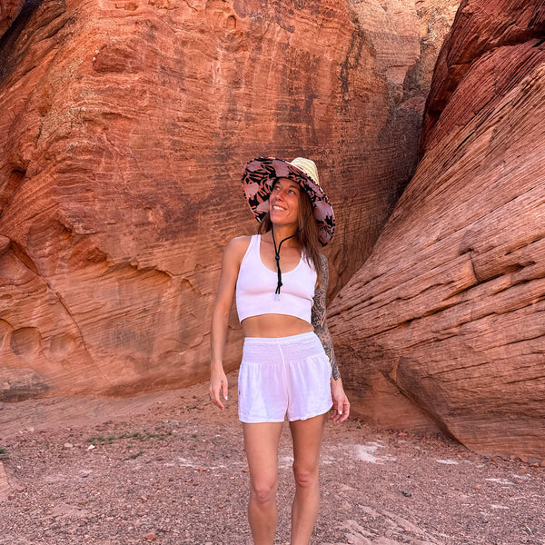 Karlene wearing The Anna Hollow Mat straw sun hat with white shorts — lifeguard style boho sun hat