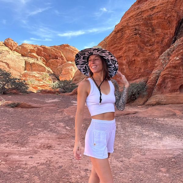 Side profile of The Jessica Hollow Mat hat on model — botanical silhouette under-brim straw sun hat