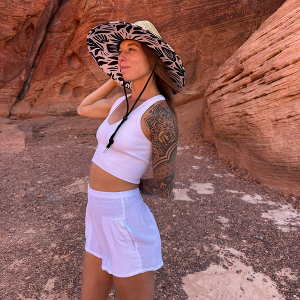 Karlene wearing The Jessica Rush & Mat hat with white shorts — botanical silhouette boho straw hat