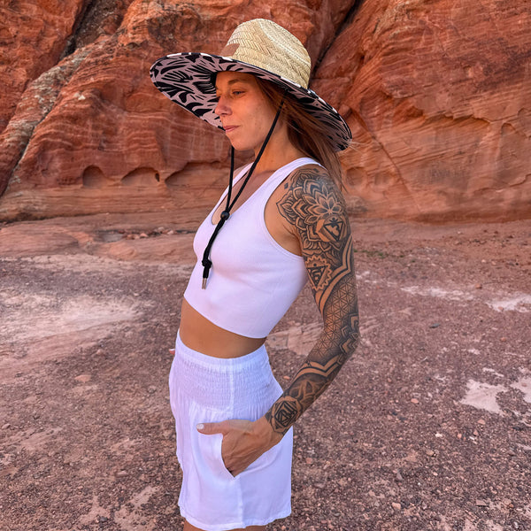 Karlene wearing The Jessica Hollow Mat straw hat with white shorts — botanical print open weave sun hat