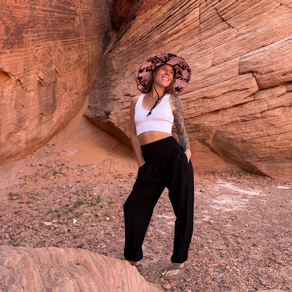 Back view of The Anna Rush & Mat hat with obsidian harem pants — fan floral under-brim boho sun hat