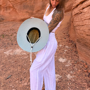 Karlene wearing The Sage Rush & Mat hat with moonlight harem pants — structured sage green sun hat
