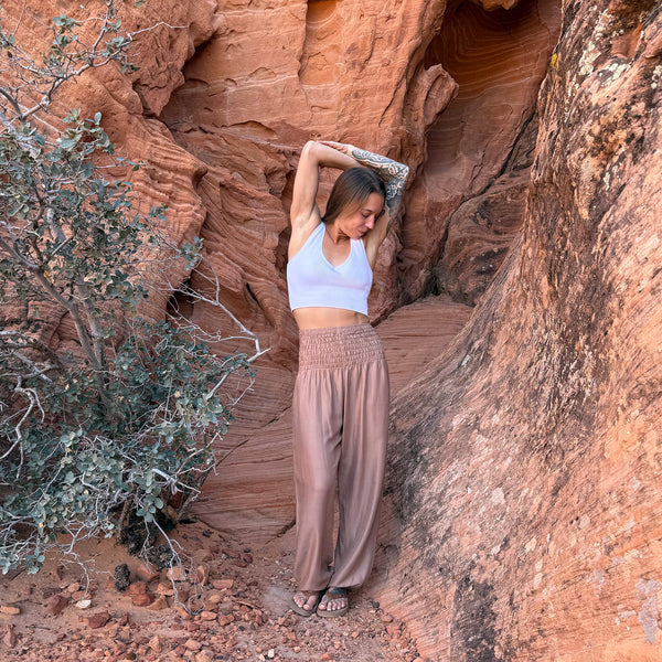 Woman in sandstone harem pants outdoors — neutral tan boho pants lifestyle