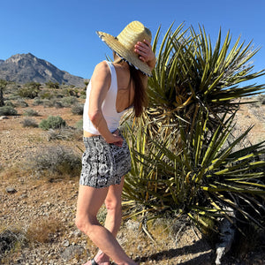 Ember Glyph Obsidian shorts worn with straw hat — boho printed shorts outfit back view