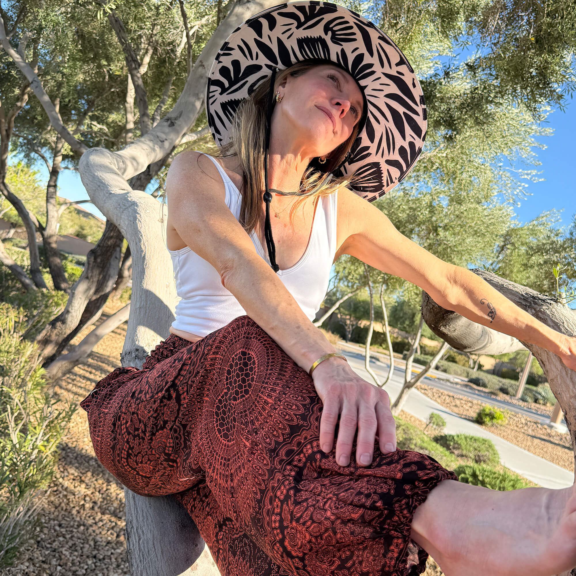 Kim wearing The Jessica Rush & Mat hat with Sierra Fire mandala harem pants — botanical print sun hat