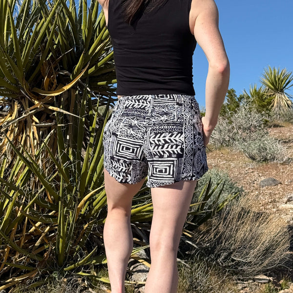 Close-up detail of Ember Glyph Ocean Wave shorts — navy geometric print boho shorts