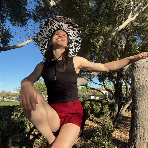 Lauren in Ruby Garnet boho shorts with Jessica straw hat — burgundy shorts outdoor style