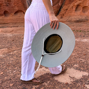 Side profile of The Sage Hollow Mat sun hat on model — earthy sage green open weave straw hat